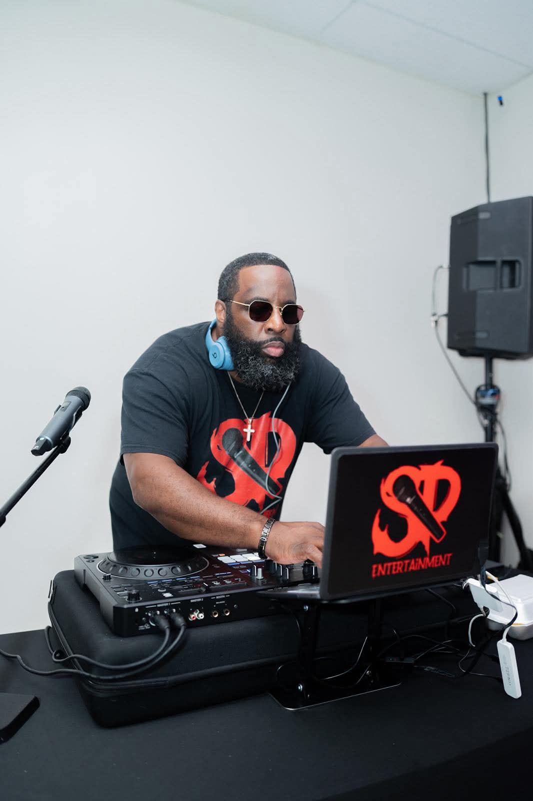 DJ Stevie Steve running a live set at a controller and laptop stand with a PA speaker behind him